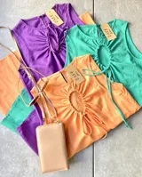 Vestido corto sin mangas con cuello redondo y detalle de lazo en el pecho. Disponible en color violeta, naranja y verde.