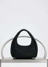 Bolso negro de mano con diseño trenzado y asa corta integrada.