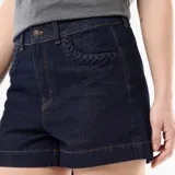Short de jean azul oscuro, de tiro alto, con detalles trenzados en los bolsillos delanteros y vuelta en el ruedo.