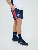 Short de baño de secado rápido, color azul, con cordón ajustable en la cintura, bolsillos laterales y el escudo del Club Nacional de Football junto al logo de Umbro bordados en las piernas.