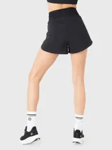 Short deportivo negro con calza incorporada, pretina ancha elástica y bolsillos laterales con cierre.