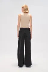 Pantalón ancho de denim negro, tiro alto y corte palazzo.