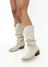 Bota tejana de cuero color beige, con caña alta y detalle de tiento cosido a mano en la parte superior. Tiene taco de 4 cm.