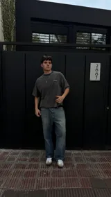 Remera gris oscura de algodón con corte boxy y estampado pequeño en el frente.