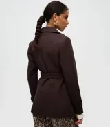 Saco de paño color marrón oscuro con cuello estructurado, solapas amplias, cierre frontal con botones y cinturón ajustable con hebilla. Cuenta con bolsillos laterales y mangas largas.