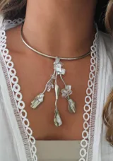Gargantilla rígida plateada con colgante de nácar y metal plateado con forma de flores y hojas.