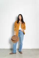 Camisa color ocre de gamuza, con cuello clásico, mangas largas con puños abotonados, cierre frontal con botones a presión y bolsillo de parche en el pecho.