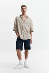 Camisa blanca de manga corta, corte oversize y cuello clásico.