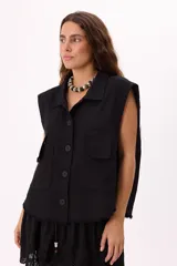 Chaleco negro sin mangas, estilo cargo con lavado suave, bolsillos frontales y botones negros.