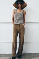 Top de algodón con estampado de rayas horizontales negras y beige, escote redondo y manga sisa.