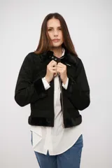 Campera de gamuza sintética negra con interior y detalles de piel sintética en cuello, puños y ruedo. Cuenta con cierre frontal y cuello con tira ajustable.