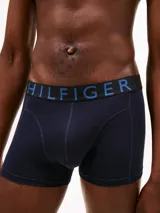 Pack de tres calzoncillos tipo trunk de algodón elástico. Cada uno presenta una cintura elástica distintiva con el logo de Tommy Hilfiger en contraste.