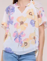 Blusa blanca de doble capa de gasa con estampado floral en tonos amarillos, celestes y rosados, escote en V con frunces y mangas cortas con volados amplios.
