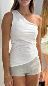 Top de un solo hombro color blanco, con diseño ajustado y detalle de frunces laterales.