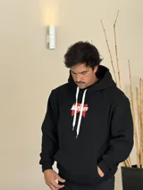 Canguro negro con capucha, de corte boxy, con estampa gráfica en la espalda que recrea el logo de Marlboro en rojo y blanco, junto con el escudo de Philip Morris y la leyenda 'Smoking kills' y 'FILTER BLACK'.