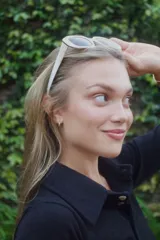 Sweater de punto fino en color verde oscuro, con cuello polo y cierre frontal de tres botones. Presenta mangas largas y un ajuste al cuerpo.