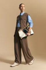 Pantalón ancho color marrón, de silueta moderna y calce cómodo, con diseño limpio y fluido. Presenta cierre frontal con botón y cordones ajustables en la cintura.