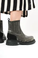 Botas de cuero negro con elásticos laterales, detalle de gamuza en el talón y suela de goma con plataforma.