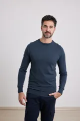 Sweater de punto liso, color azul, con escote redondo y manga larga.