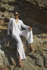 Pantalón blanco de lino, de corte ancho y con tajo lateral en el ruedo.