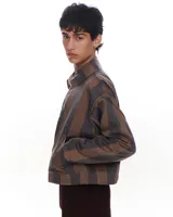 Chaqueta corta con cierre, a rayas verticales marrones y grises, con cuello clásico y bolsillos frontales.