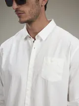 Camisa de manga larga color blanco con bolsillo en el pecho.