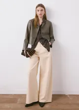 Chaqueta Sabi de cuero sintético en color verde militar, con cuello camisero, cierre frontal con botones y bolsillos de parche delanteros.