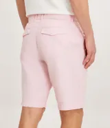 Bermuda de hombre en lino color gris claro, de corte recto, con textura discreta, bolsillos laterales y cierre frontal con botón y cremallera.