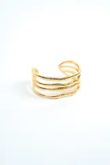 Brazalete rígido de metal dorado con diseño abierto de múltiples tiras onduladas y texturizadas.