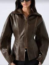 Chaqueta de efecto cuero en color marrón chocolate, con silueta entallada, cierre frontal con cremallera, cuello amplio y mangas con volumen.