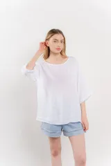 Blusa de lino color verde oliva, de corte amplio y relajado, con escote redondo y mangas 3/4 remangadas.