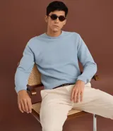 Suéter de punto para hombre, color celeste, con textura acanalada horizontal, cuello redondo y mangas largas con puños ajustados.