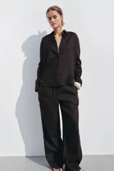 Camisa color coral confeccionada en lino 100%, de corte recto, con cuello solapa, manga larga con puños abotonados y cierre frontal con botones.