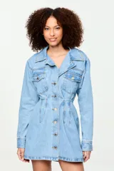 Vestido camisero corto confeccionado en denim azul claro, con cuello camisero, cierre frontal de botones metálicos, bolsillos frontales con solapa en el pecho y diseño entallado en la cintura.