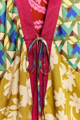 Kimono de viscosa con estampado multicolor de flores y patrones geométricos, escote en V, mangas tres cuartos y cierre frontal con tiras para anudar.