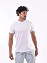 Remera blanca de manga corta con cuello redondo y un pequeño logo estampado en color verde menta en el pecho.