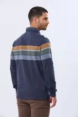 Remera polo de manga larga con diseño de rayas horizontales en tonos azul marino, marrón y gris. Presenta cuello camisero con cierre de botones y puños elásticos en las mangas.
