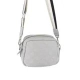 Bandolera roja de cuero sintético con diseño acolchado de rombos. Tiene correa larga de algodón regulable e intercambiable y cierre superior.