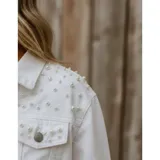 Campera de jean color negro con apliques de perlas en la parte superior frontal. Presenta cuello clásico, cierre frontal con botones metálicos y dos bolsillos en el pecho.