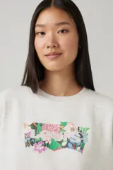 Buzo gris claro jaspeado de corte clásico, con cuello redondo y mangas largas. Estampado frontal con el logo de Levi's relleno con un diseño floral multicolor.