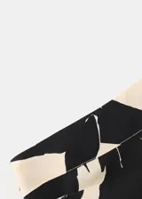 Vestido corto de viscosa con diseño asimétrico de un solo hombro y manga larga abullonada. Presenta un estampado botánico en tonos beige y negro.