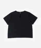 Blusa de manga corta color beige, confeccionada en tela texturizada. Presenta cuello redondo con detalle de pespuntes y cierre trasero con botón en forma de lágrima.