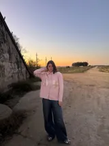 Camisa rosa de lana merino con bolsillos frontales con solapa dorada y cierre con botones. Corte recto y mangas largas.