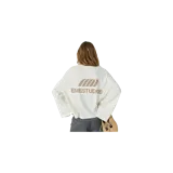 Remera de manga larga color blanco marfil con estampado frontal en tono marrón que incluye el logo y la inscripción "EMESTUDIOS".