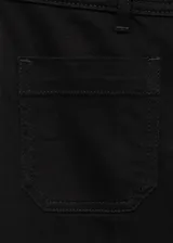 Jeans wide leg tiro alto de color negro, con cierre delantero de cremallera y botón, trabillas para cinturón y dos bolsillos de parche en la parte delantera.