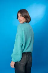 Sweater color beige de lana mohair y acrílico, con cuello redondo y mangas largas.