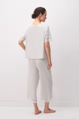 Pijama de modal jersey color gris claro melange, compuesto por una remera de manga corta con detalles de encaje en las terminaciones y un pantalón largo a juego con encaje en el ruedo.