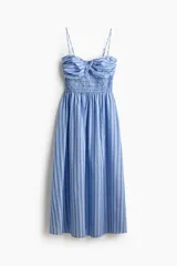 Vestido midi de algodón liviano con estampado de rayas azules y blancas, breteles spaghetti ajustables, escote corazón, cuerpo en punto smock y busto con diseño cruzado.