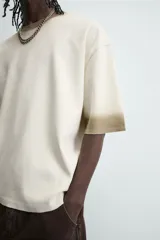 Sudadera de manga corta con cuello redondo, corte relajado y efecto lavado, en tono crudo con teñido en degradé en cuello y puños de color marrón topo.