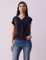 Remera azul marino de lino y poliéster, marca Zac & Rachel. Tiene escote en V con abertura y botones, y frunce en la parte delantera.